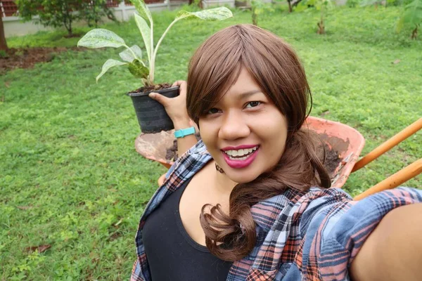 美丽的亚洲女人带着快乐的笑容 在盆子里种植着泥土自拍 — 图库照片