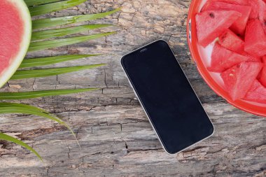 Akıllı telefonlu kırmızı karpuz yaz meyvesinin fotoğrafını çekiyorlar.