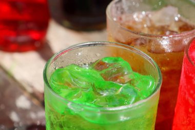 Soft drink cola red and green with ice cubes