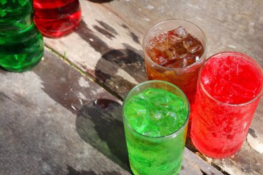 Soft drink cola red and green with ice cubes