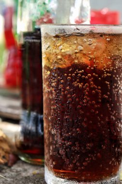 Soft drink cola red and green with ice cubes