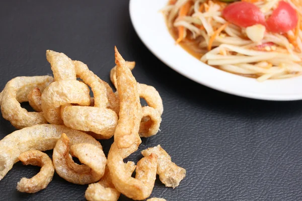 Papaja salade en gebakken varkensvlees huid — Stockfoto