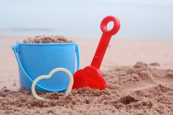 Brinquedos de praia de crianças e coração — Fotografia de Stock