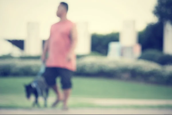 Desfocado de homem e cão no parque — Fotografia de Stock