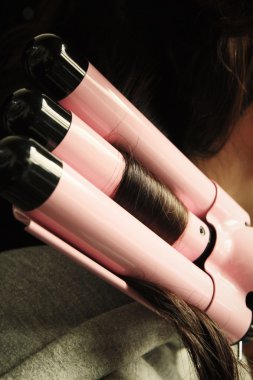 Saç düzleştirici kullanan kadın