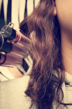 Saç düzleştirici kullanan kadın