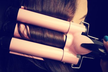 Saç düzleştirici kullanan kadın