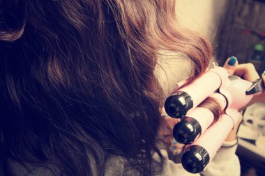 Saç düzleştirici kullanan kadın