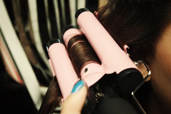 Mulher usando alisador de cabelo — Fotografia de Stock