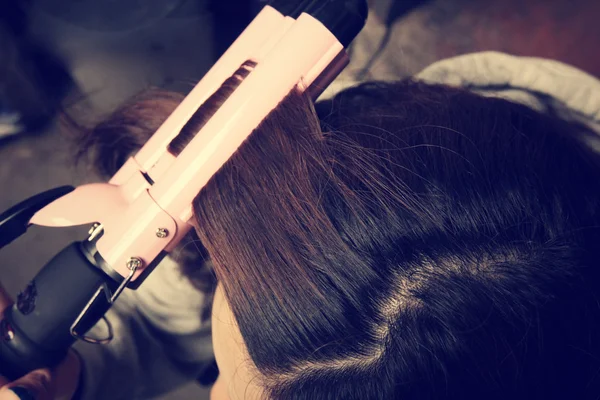 woman using hair straightener