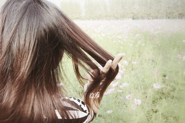 Frau mit rosa Kosmos-Blüten — Stockfoto