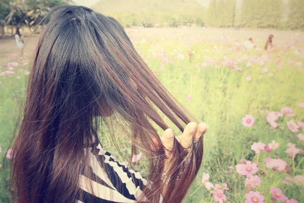 Mujer con flores de cosmos rosa — Foto de Stock