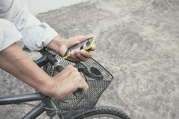 Manusia menggunakan smartphone dengan sepeda — Stok Foto