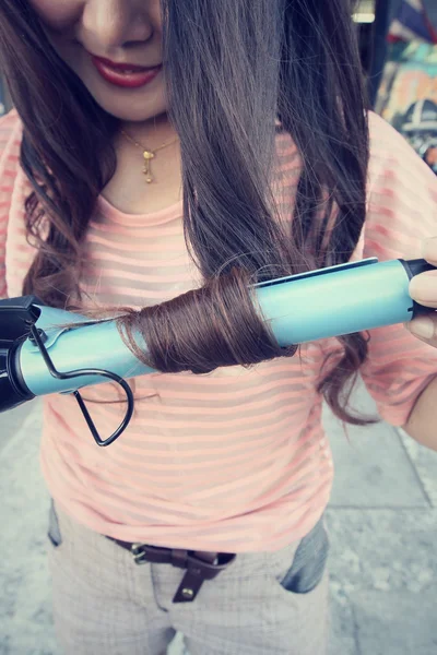 Mulher usando alisador com cabelo — Fotografia de Stock