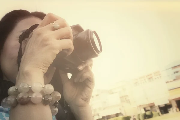 Mujer usando una cámara para tomar fotos — Foto de Stock