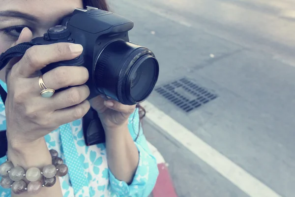 Woman using a camera to take photo — Stock Photo, Image