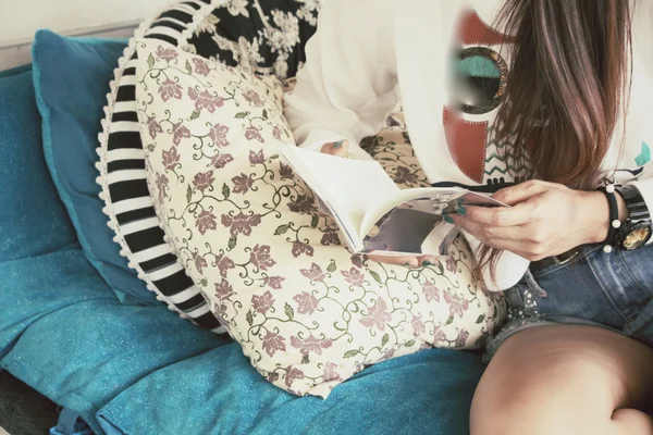 Γυναίκα διαβάζει βιβλίο στον καναπέ — Φωτογραφία Αρχείου