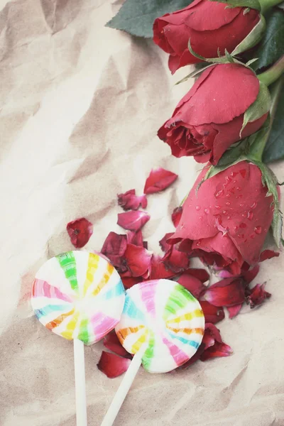 Rosas vermelhas com doces coloridos — Fotografia de Stock