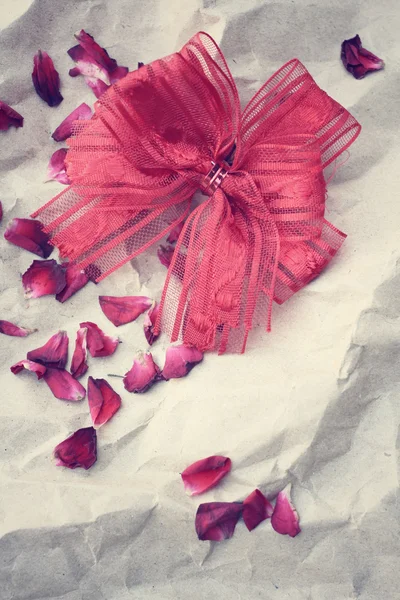 バラのリボンの弓と花びら — ストック写真