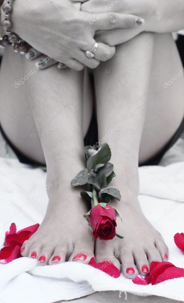 Woman foot with red rose
