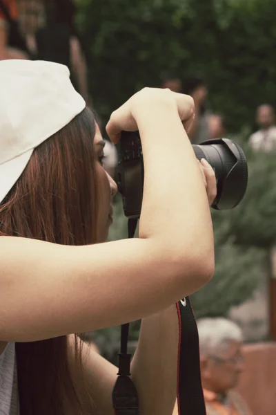 Mujer usando una cámara para tomar fotos — Foto de Stock
