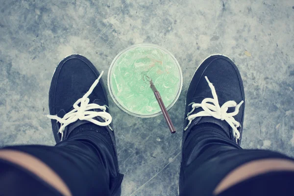 Bebida verde com tênis — Fotografia de Stock