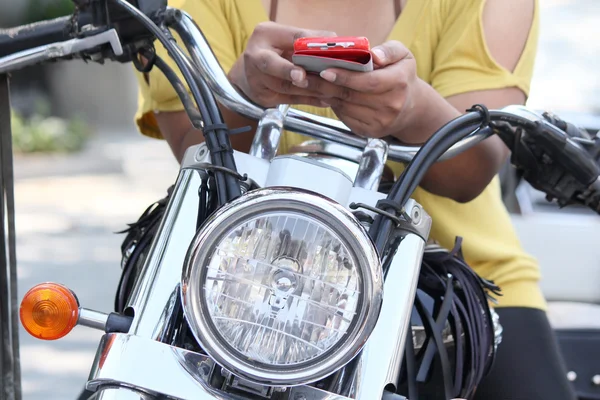 Usando telefone inteligente com motocicleta — Fotografia de Stock
