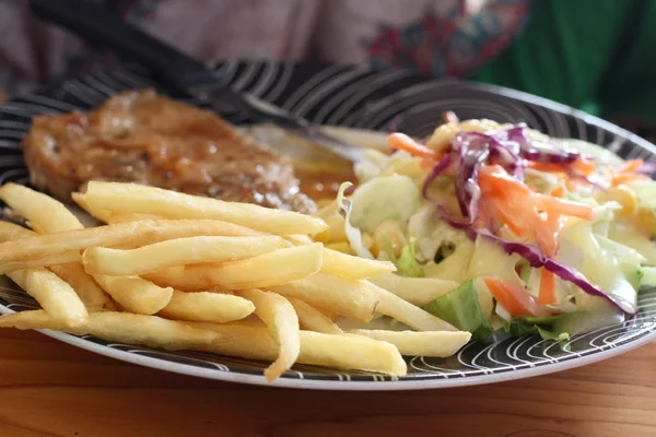 Bifes, batatas fritas com salada — Fotografia de Stock