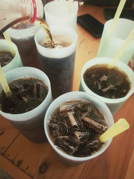 Derramando um copo de cola com cubos de gelo — Fotografia de Stock