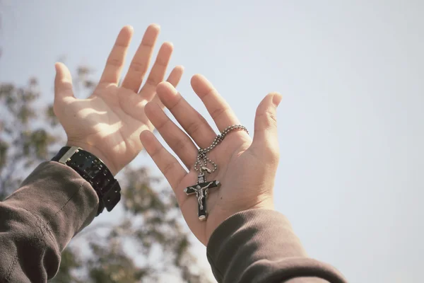 Mains tendues avec croix — Photo