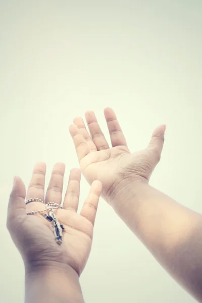 Hands reaching with cross — Stock Photo, Image
