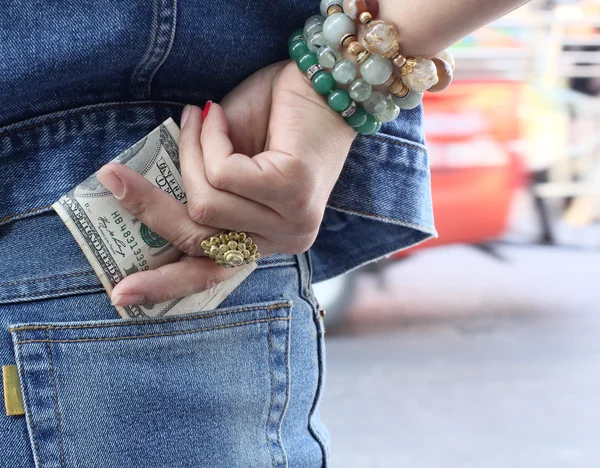 Kvinna med dollar i jeans ficka — Stockfoto
