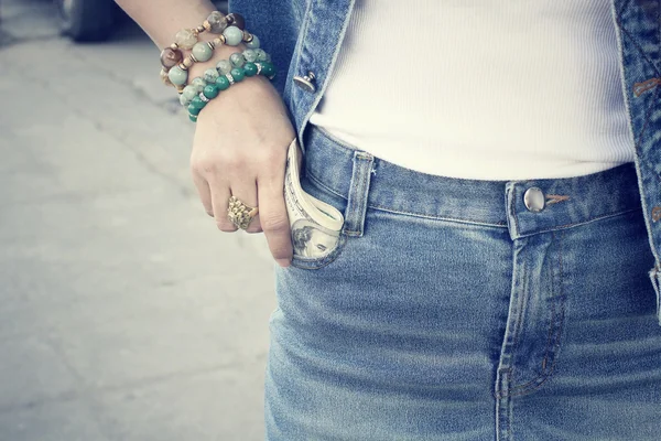 Жінка з доларом у джинсовій кишені — стокове фото