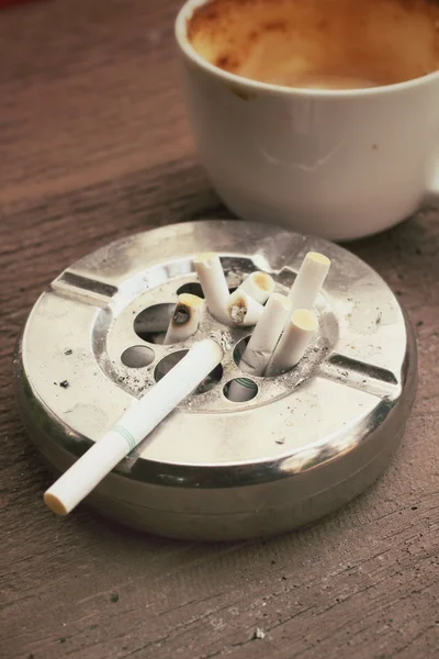 Cigarrillo con cenicero y café caliente — Foto de Stock