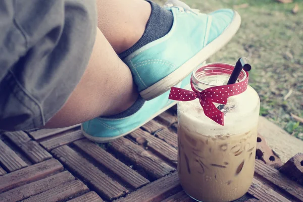 Iced coffee with sneakers — Stock Photo, Image