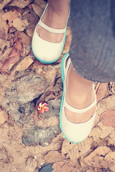 Mulher andando com sapatos nas folhas de outono — Fotografia de Stock