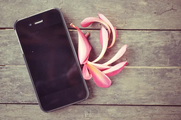 Flor rosa con teléfono inteligente — Foto de Stock
