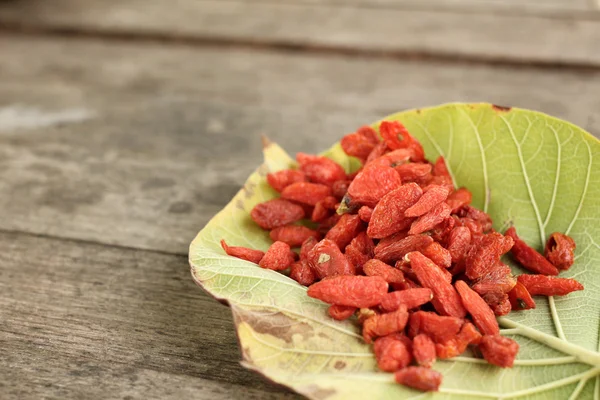 Bacche di goji essiccate su fondo di legno — Foto Stock