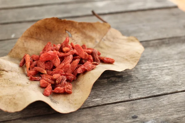 Bayas de goji secas sobre fondo de madera —  Fotos de Stock