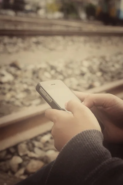 Uso del teléfono inteligente en la estación de tren — Foto de Stock