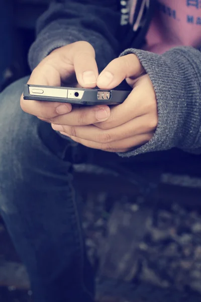 Using smart phone at railway station — Stock Photo, Image