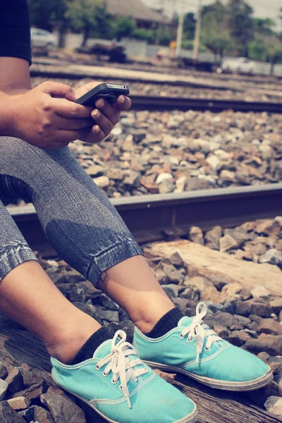 Usando telefone inteligente na estação ferroviária — Fotografia de Stock