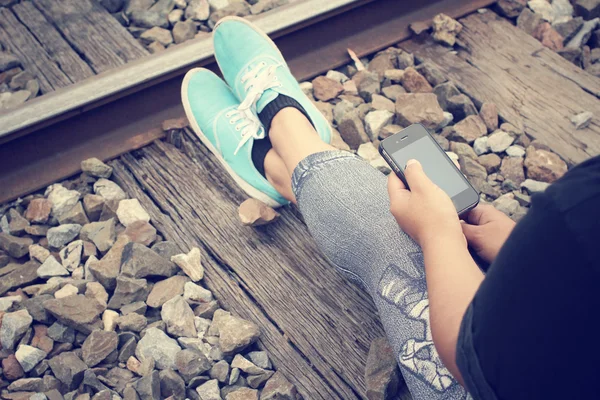 Uso del teléfono inteligente en la estación de tren —  Fotos de Stock