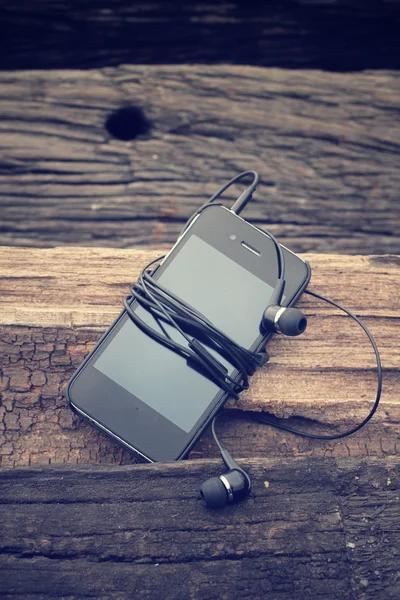 Telefone inteligente com fone de ouvido — Fotografia de Stock