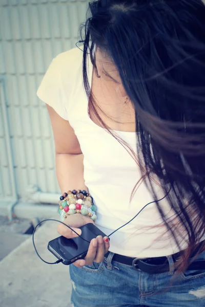 Vrouw luisteren naar muziek op oortelefoon genieten van een dans met slimme telefoon — Stockfoto