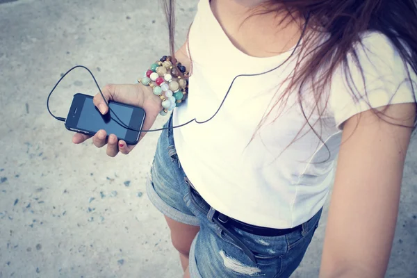 Mulher ouvindo música no fone de ouvido desfrutando de uma dança com telefone inteligente — Fotografia de Stock