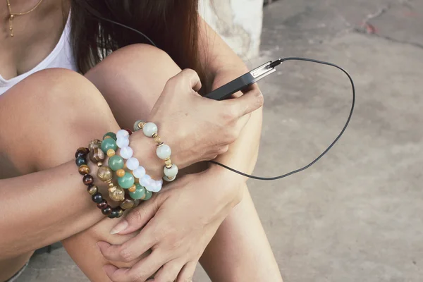 Женщина слушает музыку в наушниках со смартфоном — стоковое фото