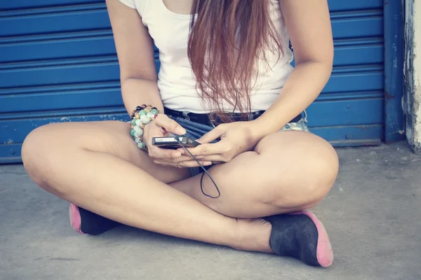 Mujer escuchando música en auriculares con teléfono inteligente —  Fotos de Stock