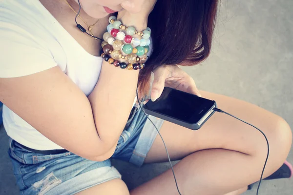 Mujer escuchando música en auriculares con teléfono inteligente —  Fotos de Stock