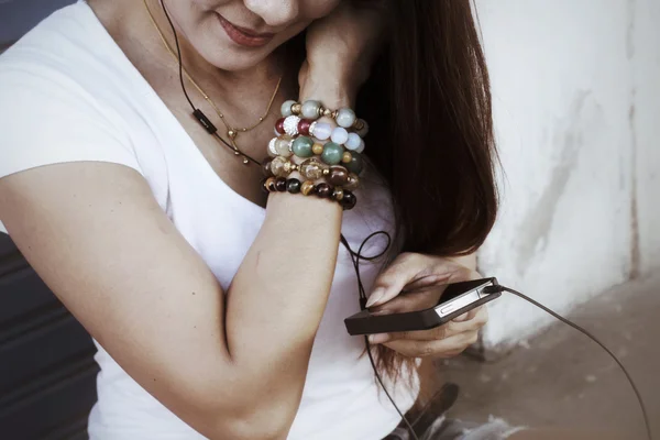 Mujer escuchando música en auriculares con teléfono inteligente —  Fotos de Stock